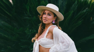 Image of Haley Reinhart in front of greenery.