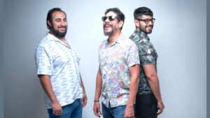 Members of Agua de Coco standing together in front of a white backdrop.