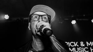 Black and white image of MC Homeless performing on stage.